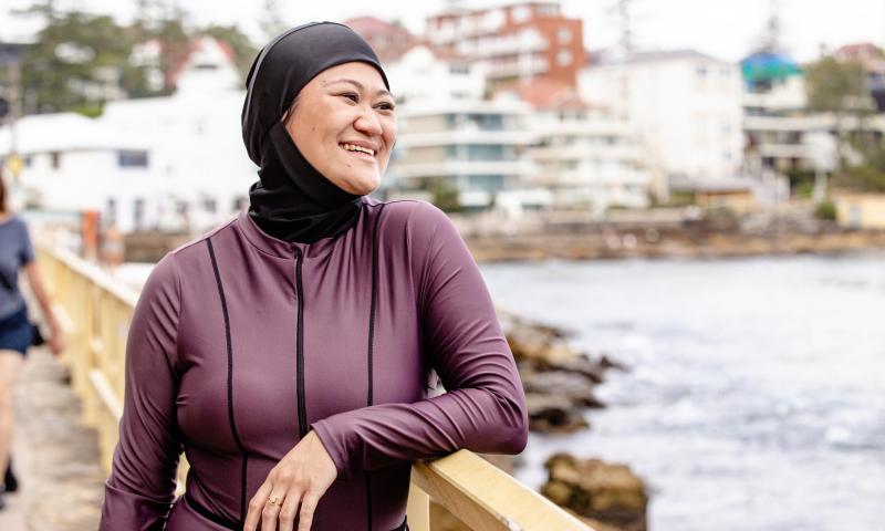 A woman enjoying time outdoors by the water, wearing modest swimwear suited to her needs.